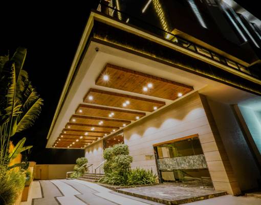 Entrance view of VS Imperial, one of the top hotels in Akola, featuring elegant lighting, landscaped greenery, and modern architecture 